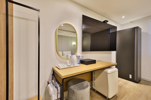 a bathroom with a vanity with a mirror and a sink at Hotel Rubato Ulsan Jung-gu Haksung in Ulsan