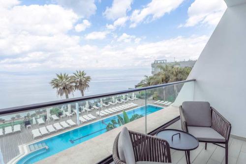 a balcony with chairs and a view of the ocean at Golan Hotel in Tiberias