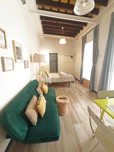 a living room with a green couch and a bed at Apartamentos La Higuera by VGH in Jerez de la Frontera