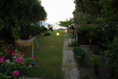 a garden with a hammock and a yard with flowers at Beach Villa Next To The Waves! in Istiaía