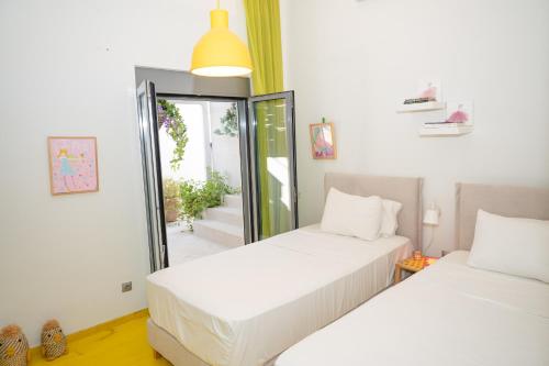 2 weiße Betten in einem Zimmer mit Fenster in der Unterkunft Beach Villa Next To The Waves! in Istiaía