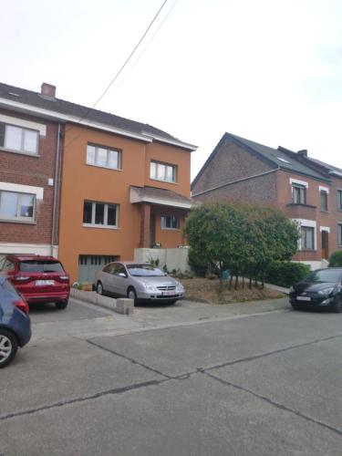a parking lot with cars parked in front of buildings at Beatrice's gardens in Nivelles