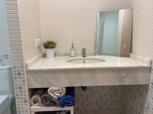 een witte badkamer met een wastafel en een spiegel bij Horia Seaside in La Herradura