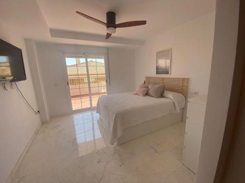 een slaapkamer met een bed en een plafondventilator bij Horia Seaside in La Herradura
