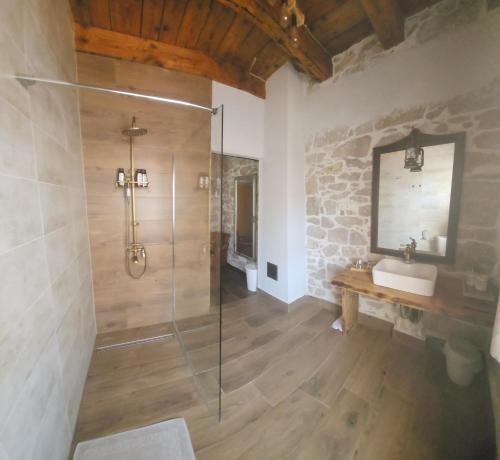 a bathroom with a glass shower and a sink at Boutique Vila Marijini Dvori in Tribunj