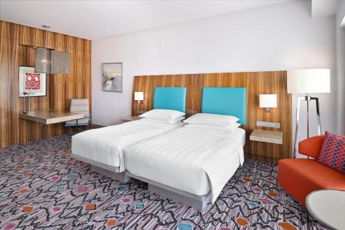 a bedroom with a large white bed and a red couch at Andaz Capital Gate Abu Dhabi, By Hyatt in Abu Dhabi
