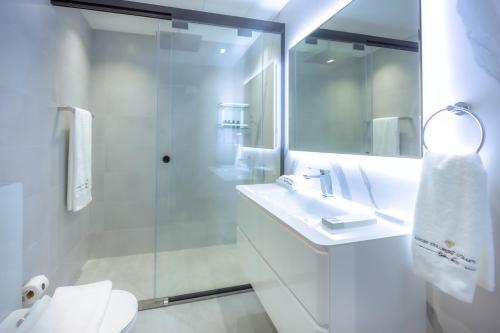 a white bathroom with a sink and a shower at Villa Mallorca - Exclusive 11-Bedroom Villa with signature Amenities By Luxury Explorers Collection in Dubai