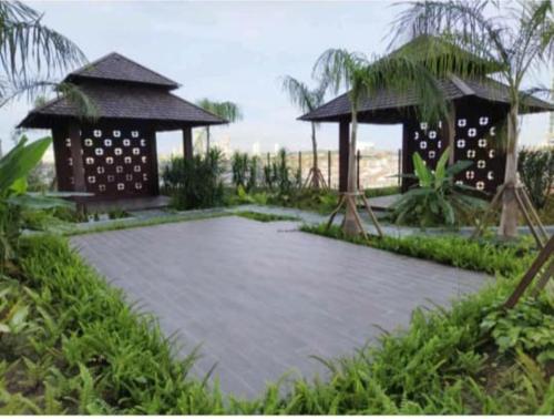 a walkway with a gazebo in the middle of a garden at Bali Residence Melaka by Naufal in Melaka