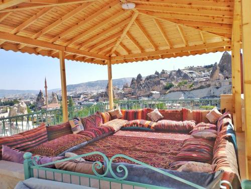 a group of couches sitting under a wooden roof at Gedik Cave Hotel in Goreme