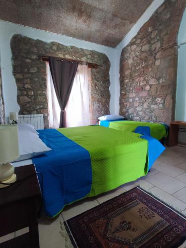 a bedroom with a green and blue bed with a window at Agriturismo Il Borgo della Canapa in San Benedetto