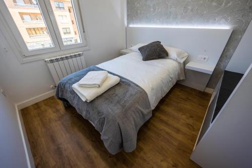 a small bedroom with a bed with two towels on it at El balcón del Poeta in El Burgo de Osma