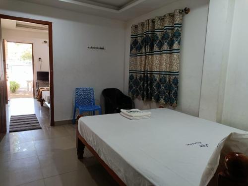 um quarto com uma cama e um quarto com uma porta em Hotel Blue Coral Rameswaram em Rameswaram