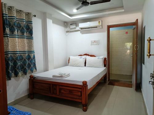 um pequeno quarto com uma cama num quarto em Hotel Blue Coral Rameswaram em Rameswaram