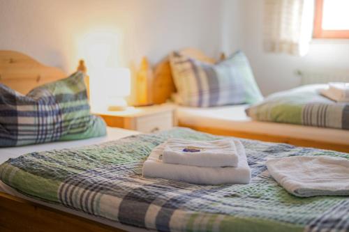 a bedroom with two beds with towels on the bed at Hotel Restaurant Biesenbach in Wipperfürth