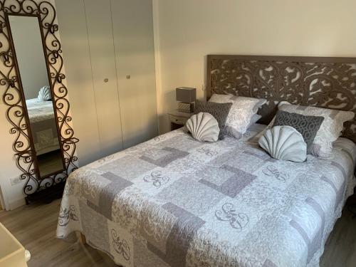 - une chambre avec un grand lit, des oreillers et un miroir dans l'établissement Merazur, à Saint-Raphaël
