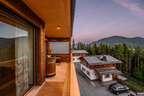 un balcón de una casa con un coche en Das Eulersberg Apartments & Chalets, en Werfenweng