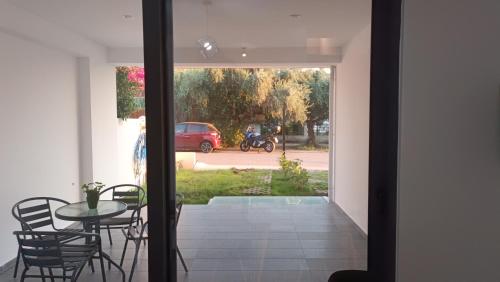 a glass door leading to a patio with a table and chairs at Pagani Green - Luxury Maisonette I2 in Kalamata