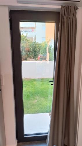 a window with a view of a yard at Pagani Green - Luxury Maisonette I2 in Kalamata