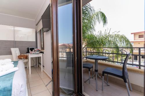 a room with a balcony with a bed and a table and chairs at B&B Golden House & spa in Rose