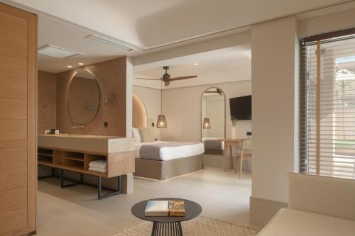 a hotel room with a bed and a bathroom at Paralos Venus Suites Adults Only in Hersonissos