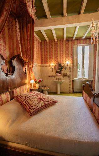 une chambre avec un grand lit et un lavabo dans l'établissement Maison de Maître avec Grand Parc arboré clos de murs, à Nérac