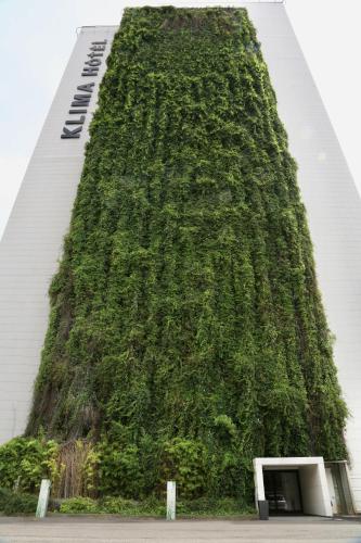 a tall building with a green wall at Klima Hotel Milano Fiere in Milan