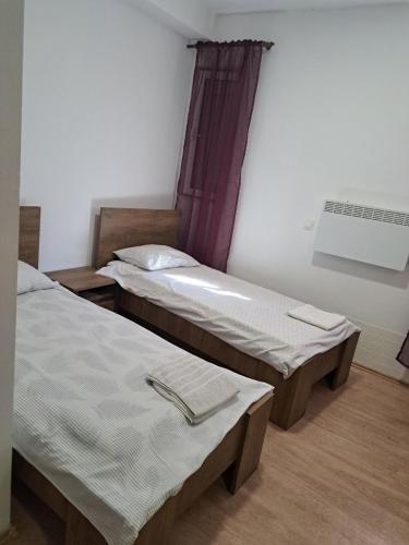 two twin beds in a room with a window at Villa Ika in Ploče