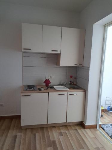 una cucina con mobili bianchi e un lavandino di Villa Ika a Ploče (Porto Tolero)