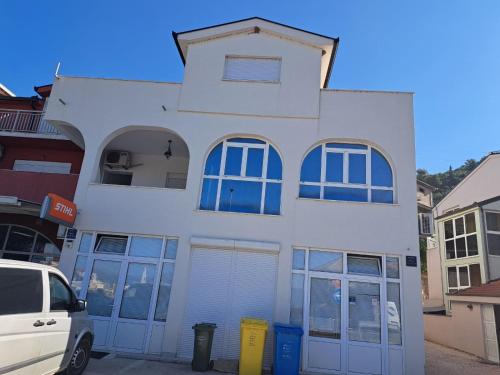 un edificio bianco con porte e finestre blu di Villa Ika a Ploče (Porto Tolero)