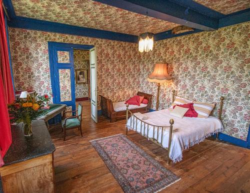 een slaapkamer met een bed en een bureau. bij Maison de Maître avec Grand Parc arboré clos de murs in Nérac