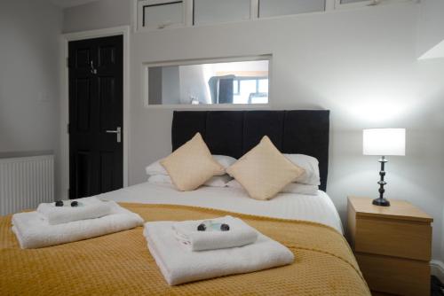 a bedroom with a bed with two towels on it at Coasters Holiday Apartments in Skegness