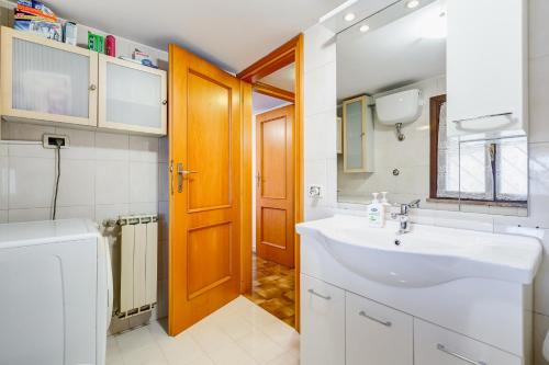 a bathroom with a sink and a wooden door at HomeSweetHome near Rome in Monterotondo