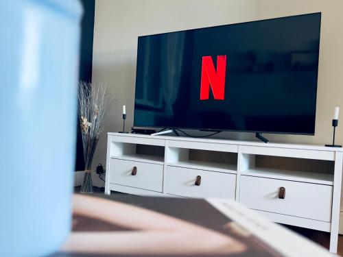 - une télévision sur une commode blanche dans l'établissement 