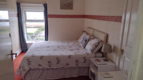 um pequeno quarto com uma cama e uma janela em The Kathrene Second Floor Sea View em Fleetwood