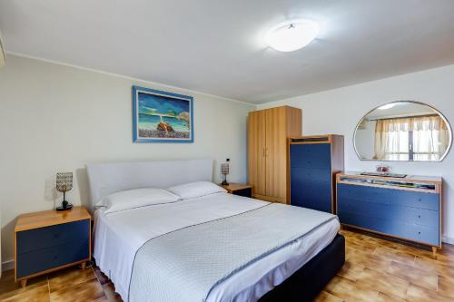 1 dormitorio con cama, armarios azules y espejo en HomeSweetHome near Rome, en Monterotondo