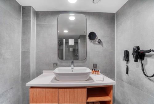 a bathroom with a sink and a mirror at İbos Hotels Izmir in Izmir