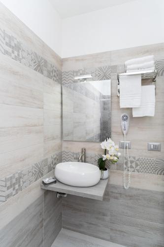 a bathroom with a sink and a mirror at B&B Golden House & spa in Rose