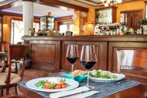 a table with two glasses of wine and a plate of food at La Vecchia Fonte Boutique Hotel in Palau