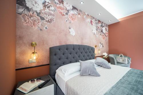 a bedroom with a bed and a floral wall at B&B Golden House & spa in Rose