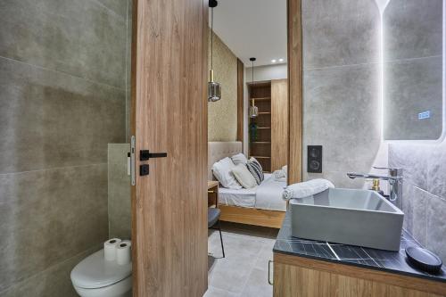 Appartement Coeur Montmartre by Studio prestige في باريس: حمام مع حوض ومرحاض وسرير