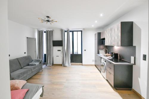un salon avec un canapé et une cuisine dans l'établissement Parking Gratuit - Montmartre Charme & Patio Privé - Sacré-Cœur Metro Anvers, à Paris