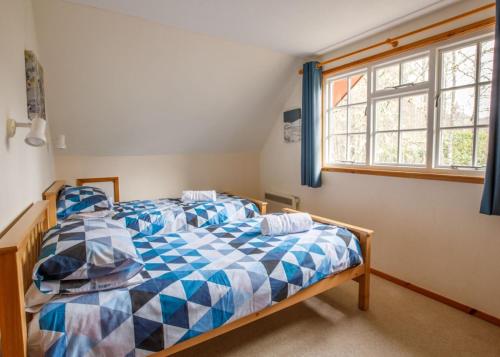 a bedroom with two beds and a window at Pheasant Lodge in Tomich