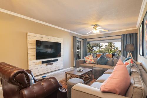 a living room with a couch and a tv at La Pirogue 14 in Ballito