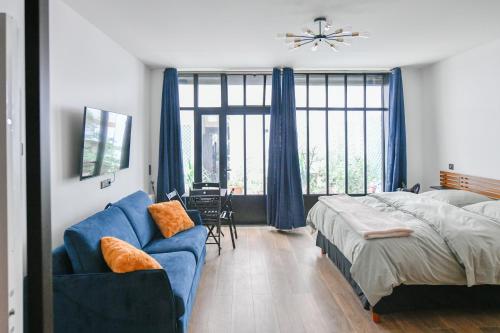 una camera con un letto e un divano blu di Montmartre Charme et Élégance près du Sacré-Cœur a Parigi
