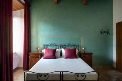 a bedroom with a large bed with red pillows at Hotel San Marco in Gubbio