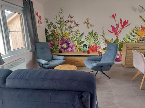 a living room with a flower mural on the wall at Au chalet des bergeronnettes. in Somme-Leuze