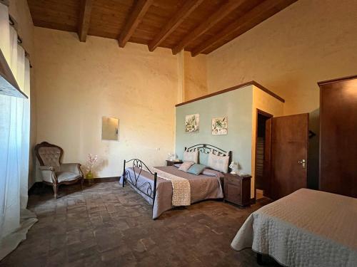 1 dormitorio con 1 cama y 1 silla en Palatium Le Caselle, en Viterbo
