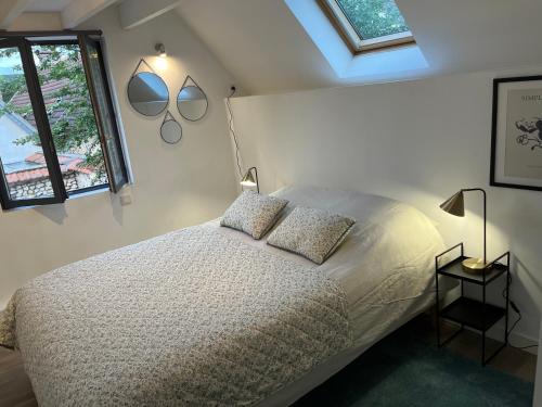 une chambre avec un lit et deux miroirs au mur dans l'établissement Maison avec jardin au cœur de Vernon, à Vernon