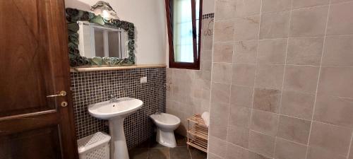 uma casa de banho com um lavatório e um WC em Casa Maya em Valledoria