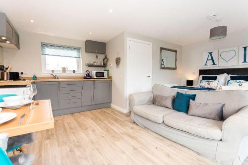 a living room with a couch and a kitchen at Annabelle's Den in Gatehouse of Fleet